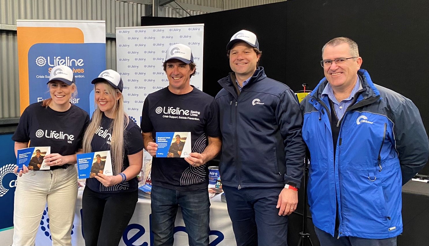 Lifeline volunteers and Brad Hogg and CBH staff holding crisis book at Newdegate Field Day 