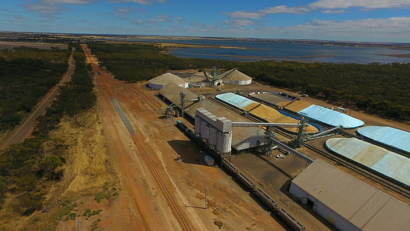 Drone aerial of the CBH Newdegate receival site showing silos, open bulk heads and a lake in the background