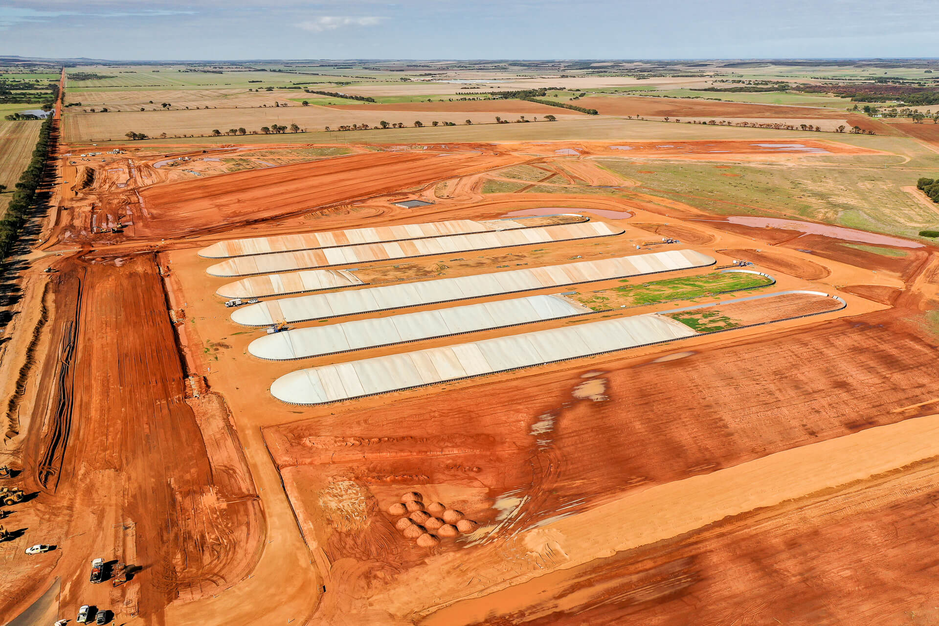 Aerial shot showing the orange dirt of Narngulu and a series of white open bulkheads, with lots of exposed dirt.